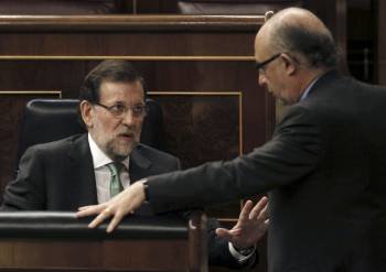 Mariano Rajoy habla con Cristóbal Montoro durante la sesión plenaria en el Congreso. (Foto: PACO CAMPOS)