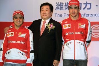 Los pilotos de Ferrar Felipe Massa y Fernando Alonso  posan junto a Tan Xuguang, presidente ejecutivo de Weichai Power.
