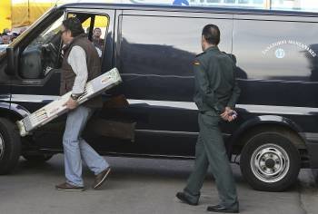 Un agente porta una caja con la escopeta con la que el hombre mató a sus dos hijos y a su suegra. (Foto: M.C. MORENO)
