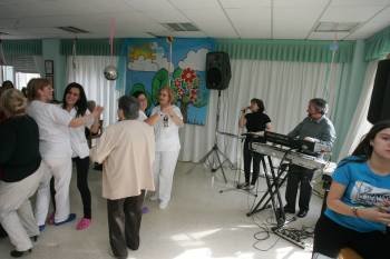 Trabajadoras y residentes bailan en el centro de Os Gozos, de la Fundación San Rosendo. (Foto: MARCOS ATRIO)