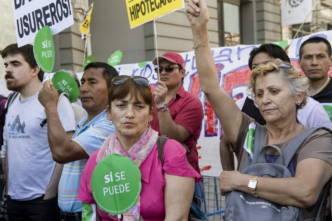 Varias personas durante la concentración convocada por la Plataforma de Afectados por la Hipoteca (PAH) en la plaza madrileña de Neptuno, en las inmediaciones del Congreso (Foto: EFE)