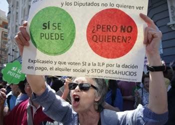 Una mujer sostiene una pancarta durante la protesta de la PAH frente al Congreso de los Diputados. (Foto: J.C. HIDALGO)