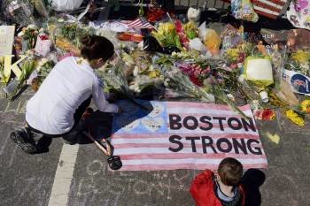 Una mujer y un niño depositan flores en el lugar de los atentados de Boston. (Foto: MICHAEL REYNOLDS)