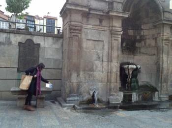 Unha muller deposita un libro nas Burgas de Ourense o pasado ano.