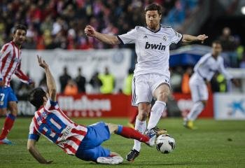 El centrocampista del Real Madrid Xabi Alonso (d) pelea un balón con el defensa del Atlético de Madrid Juanfran Torres (Foto: EFE)