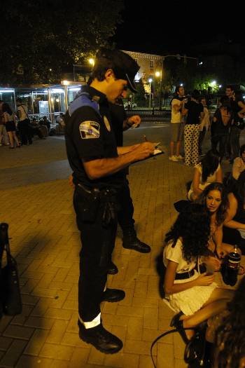 Un policía local identifica a participantes en un botellón. (Foto: MIGUEL ANGEL)