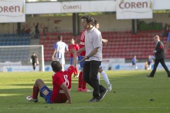 Luisito, entrenador del Ourense, trata de consolar a un cansado Adil, sentado sobre el césped. (Foto: FOTOS: MIGUEL ÁNGEL)