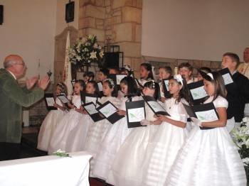 Un grupo de niños canta en el coro durante la ceremonia de su Primera Comunión. (Foto: ARCHIVO)