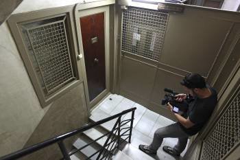 Un cámara toma imágenes de la puerta del domicilio donde fue encontrado el cadáver. (Foto: MARTA PÉREZ)