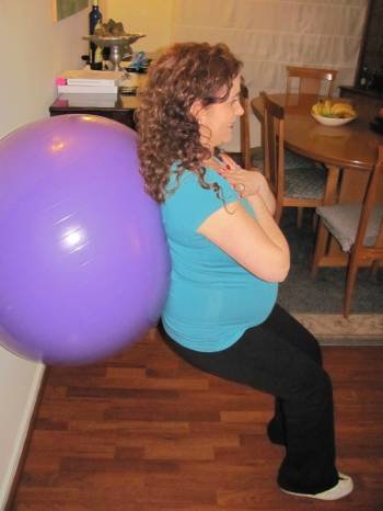 Una mujer embarazada realiza ejercicio físico en el salón de su casa. (Foto: ARCHIVO)