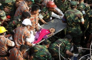 Miembros de los servicios de rescate evacuan a una mujer encontrada con vida entre los escombros del complejo textil que se derrumbó el pasado 24 de abril cerca de Daca (Bangladés) (Foto: EFE)