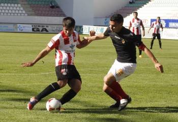 Yosu, capitán del Ourense, trata de impedir la progresión de un jugador del conjunto zamorano. (Foto: MARIAM MONTESINOS)