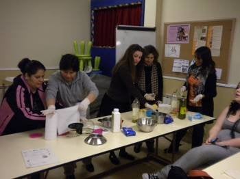 Un grupo de mujeres inmigrantes asiste a una clase práctica durante un taller de cocina. 