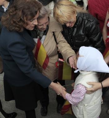 La alcaldesa de Madrid, Ana Botella (i), saluda a una niña vestida de chulapa en la plaza de Colón.