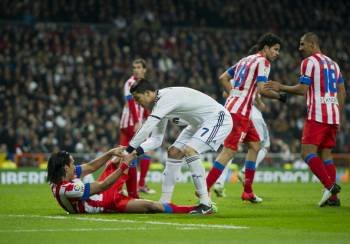 Cristiano Ronaldo ayuda a levantarse al jugador del Atlético de Madrid Falcao.