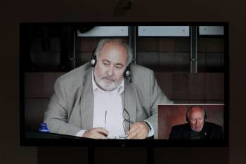 Imagen del circuito televisivo de la sala que muestra a Kostazos y Mangouras (abajo) en el juicio. (Foto: CABALAR)