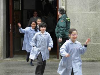 Un grupo de escolares saliendo con rapidez del edificio.