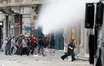 Los manifestantes intentan esquivar un chorro de agua en Estambul. (Foto: YAKUP KABUP)
