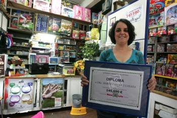 Marta Vázquez Losada posa con el cartel del premio repartido esta semana en su negocio. (Foto: MARTIÑO PINAL)