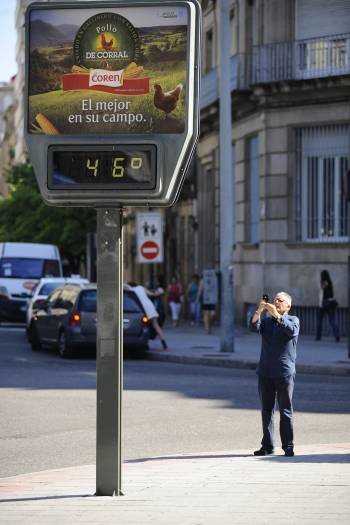 Un paseante fotografía el termómetro de San Lázaro. (Foto: MARTIÑO PINAL)
