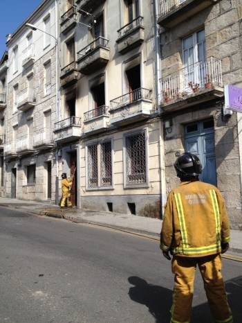 Un bombero, a la puerta del edificio afectado. (Foto: M.A.)