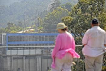 Dos personas observan las labores de extinción en la central hidroeléctrica. (Foto: MARTIÑO PINAL)