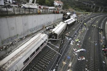 Los servicios de emergencia trabajan junto a las vías tras el accidente del tren Alvia que cubría la ruta entre Madrid y Ferrol y que descarriló anoche cuando ya estaba muy cerca de Santiago de Compostela (Foto: efe)