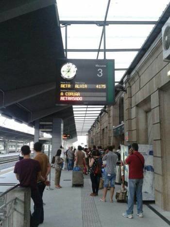 Pasajeros en la Estación Empalme esperando un tren a las 21,10 con el panel avisando del retraso de un tren Alvia media hora después del trágico descarrilamiento a la entrada de Santiago. (Foto: A. NESPEREIRA)