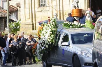 Os pais de Ana Alvarez, conmocionados, detrás do coche fúnebre que traslada o féretro (á dereita) ó interior da iglesia de Melias. (Foto: FOTOS: MARTIÑO PINAL)