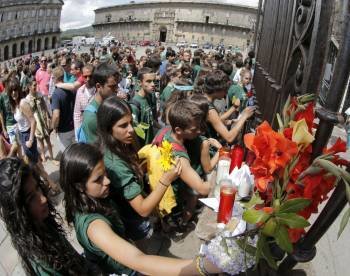 Peregrinos y turistas depositan flores y velas en la fachada de la catedral de Santiago. (Foto: XOAN REY)