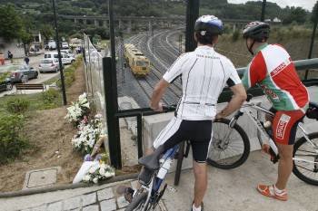 Dos ciclistas observan la vía donde el pasado miércoles descarriló el tren Alvia, que causó 79 víctimas.  (Foto: E. TRIGO)