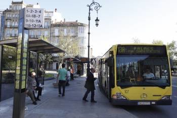 Un autobús urbano recoge pasajeros en la parada de la Alameda. (Foto: XESÚS FARIÑAS)