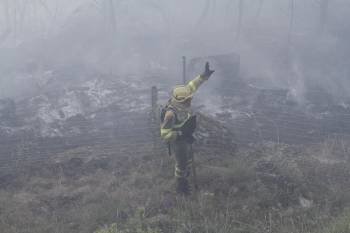 Un integrante de una de las brigadas alerta al resto de su equipo para seguir extinguiendo las llamas. (Foto: MGUEL ÁNGEL)