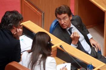 Núñez Feijóo habla con el portavoz parlamentario del PPdeG, Pedro Puy, durante la sesión plenaria. (Foto: VICENTE PERNÍA)