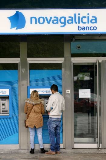 Unos clientes utilizan un cajero automático de NCG Banco. (Foto: ARCHIVO)