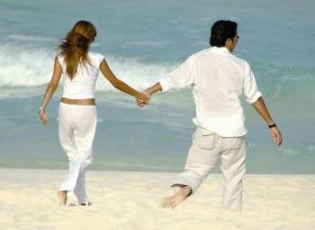 Una pareja pasea por la playa.