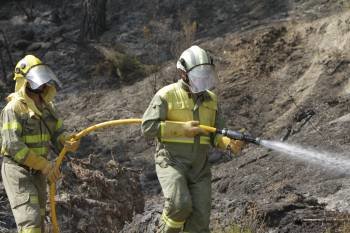 Dos miembros de una brigada autonómica, en labores de refresco tras el incendio de Larouco. (Foto: MIGUEL ÁNGEL)