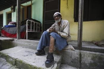 Un enfermo de lepra sentado a las puertas de una leprosería en Srinagar, la capital estival de la parte de Cachemira administrada por la India, en julio. (Foto: EFE )