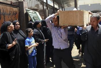 Varios hombres portan un ataúd que contiene los restos de un simpatizante de los Hermanos Musulmanes muerto en El Cairo. (Foto: AHMED ASSADI)