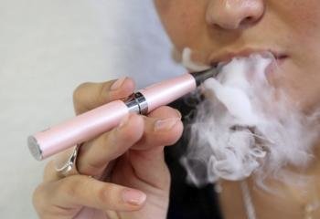 Mujer aspirando el vapor de un cigarrillo electrónico. (Foto: EFE )