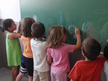 Un grupo de niños trabaja en la pizarra en una clase en un aula mixta durante la jornada escolar.