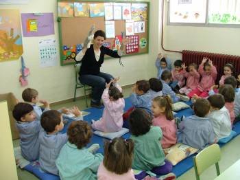Un grupo de niños y niñas juegan en un aula de infantil en un centro.