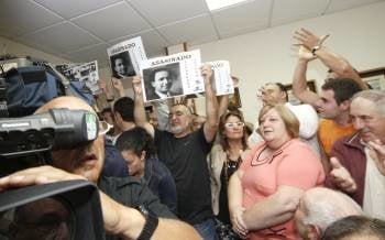 Algunos asistentes al pleno acudieron con fotos de víctimas de la represión franquista. (Foto: ELISEO TRIGO)
