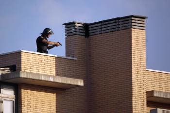 Un agente de policía en la azotea del edificio de la calle Niceto Alcalá Zamora de Madrid.  (Foto: EMILIO NARANJO)