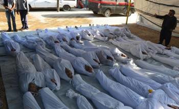 Los activistas sirios muestran varios cadáveres tras el supuesto ataque con armas químicas.