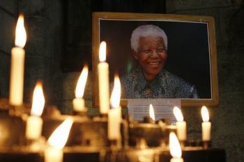 Numerosos candelabros encendidos junto a un retrato del expresidente sudafricano Nelson Mandela, en una altar de la iglesia de San Jorge, en Ciudad del Cabo (Sudáfrica) (Foto: EFE )