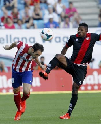 Juanfran, del Atlético, cabecea un balón ante Lass. (Foto: A.MARTÍN)