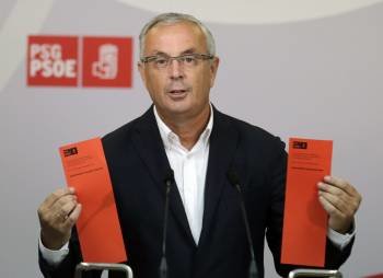 El secretario xeral del PSdeG, Pachi Vázquez, muestra las papeletas de los dos candidatos. (Foto: LAVANDEIRA JR)