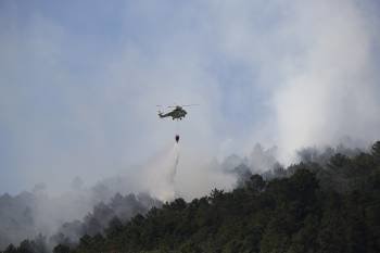 Un helicóptero interviene en las labores de extinción en A Peroxa. (Foto: XESÚS FARIÑAS)