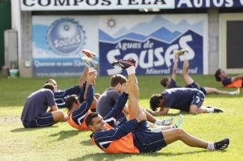 Los jugadores del CD Ourense, ayer estirando durante el entrenamiento previo al partido. (Foto: XESÚS FARIÑAS)